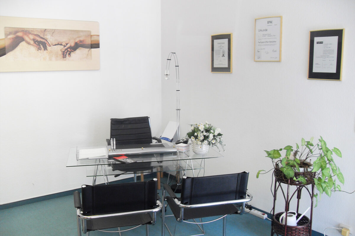 Büro mit Glastisch und schwarzen Stühlen